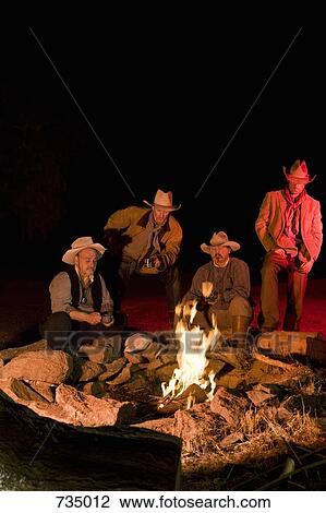 Cowboys sitting around a campfire at night View Large Photo Image Stock Image - Cowboys sitting around a campfire at night. Fotosearch