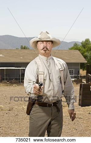 Portrait of a cowboy aiming his gun View Large Photo Image Stock Image - Portrait of a cowboy aiming his gun. Fotosearch