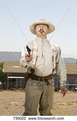 Portrait of a cowboy aiming his gun View Large Photo Image Stock Image - Portrait of a cowboy aiming his gun. Fotosearch