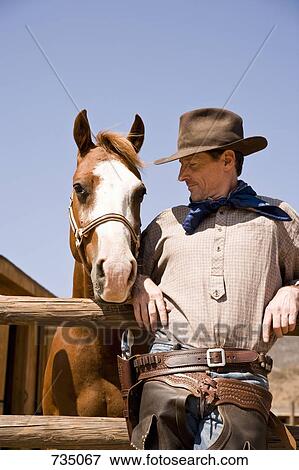Portrait of cowboy standing next to a horse View Large Photo Image Stock Photo - Portrait of cowboy standing next to a horse. Fotosearch