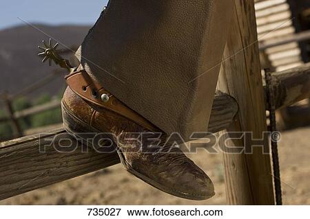 The leather boot of a cowboy resting on a fence View Large Photo Image Stock Photo - The leather boot of a cowboy resting on a fence. Fotosearch