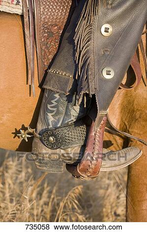 The leg of a cowboy in a horse stirrup View Large Photo Image Stock Photo - The leg of a cowboy in a horse stirrup. Fotosearch
