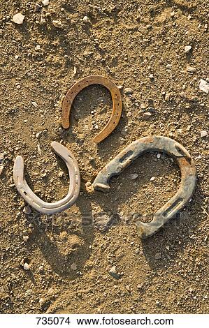 Picture - Three horseshoes on the ground. Fotosearch