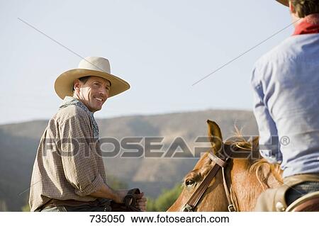 Two cowboys riding horses View Large Photo Image Stock Image - Two cowboys riding horses. Fotosearch