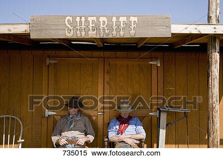 Two cowboys sitting outside the office of the Sheriff View Large Photo Image Stock Photography - Two cowboys sitting outside the office of the Sheriff. Fotosearch