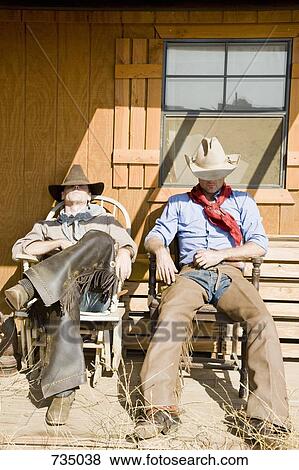 Two cowboys sleeping in chairs View Large Photo Image Stock Photo - Two cowboys sleeping in chairs. Fotosearch