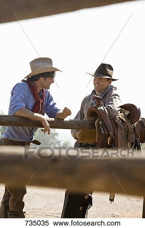 Two ranchers talking next to a fence View Large Photo Image Stock Photography - Two ranchers talking next to a fence. Fotosearch