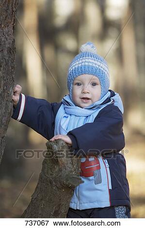 A baby boy leaning on a tree stump View Large Photo Image Stock Photo - A baby boy leaning on a tree stump. Fotosearch