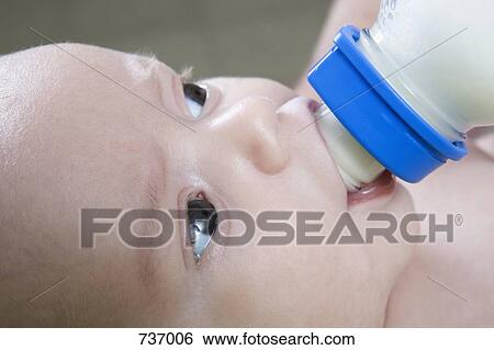 Stock Photograph - A baby drinking a bottle. Fotosearch