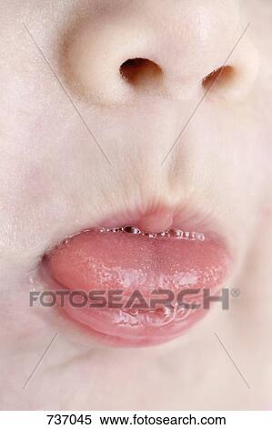 A child sticking out its tongue, extreme close-up View Large Photo Image Stock Photography - A child sticking out its tongue, extreme close-up. Fotosearch
