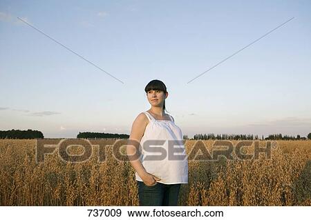A pregnant woman standing near a wheat field View Large Photo Image Stock Photo - A pregnant woman standing near a wheat field. Fotosearch