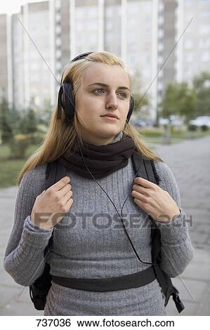A teenage girl wearing headphones waiting View Large Photo Image Stock Photograph - A teenage girl wearing headphones waiting. Fotosearch
