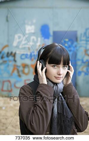 A teenage girl wearing headphones, outdoors View Large Photo Image Stock Photography - A teenage girl wearing headphones, outdoors. Fotosearch