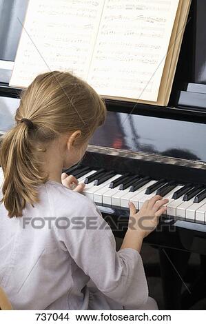 A young girl playing piano View Large Photo Image Picture - A young girl playing piano. Fotosearch