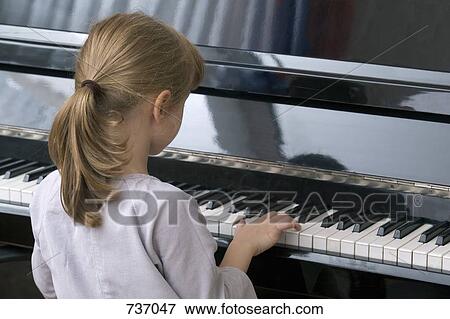 A young girl playing piano View Large Photo Image Stock Photo - A young girl playing piano. Fotosearch