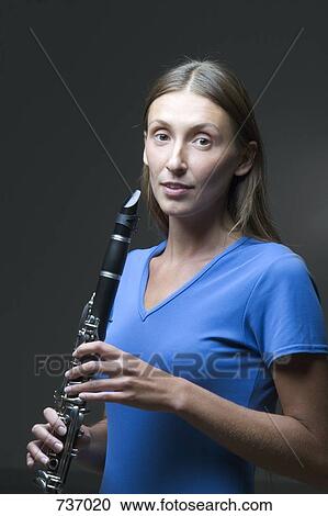 Stock Image - A young woman holding a clarinet. Fotosearch