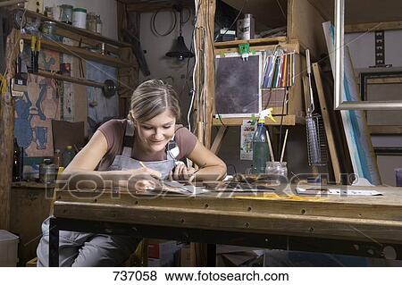 Stock Photo - A young woman working in an art studio. Fotosearch