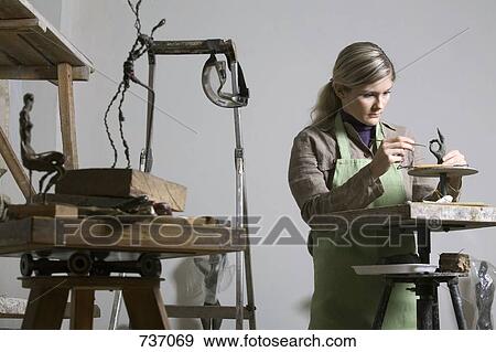 Stock Photo - A young woman working in an art studio. Fotosearch
