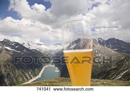 A beer glass in front of a view of the Austrian Alps View Large Photo Image Stock Image - A beer glass in front of a view of the Austrian Alps. Fotosearch