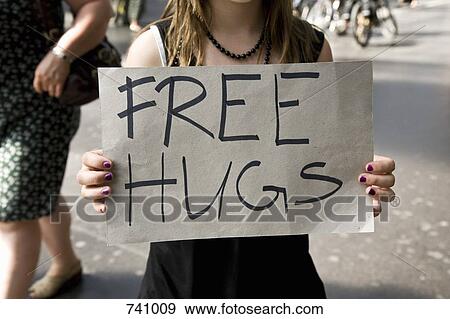 A young woman holding a sign saying Free Hugs View Large Photo Image Stock Photo - A young woman holding a sign saying Free Hugs. Fotosearch