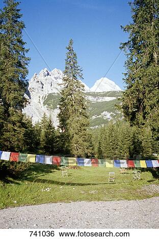 Multicolored bunting across a garden in the Austrian Alps View Large Photo Image Stock Photograph - Multicolored bunting across a garden in the Austrian Alps. Fotosearch