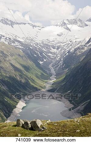 View of a valley and reservoir in the Austrian Alps View Large Photo Image Stock Photo - View of a valley and reservoir in the Austrian Alps. Fotosearch