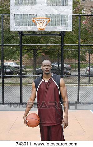A basketball player holding a ball, portrait View Large Photo Image Stock Image - A basketball player holding a ball, portrait. Fotosearch