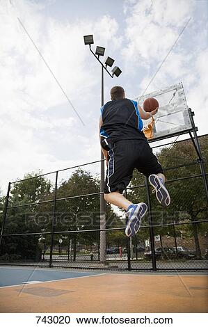Stock Image - A basketball player making a lay up shot. Fotosearch