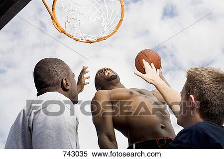 Stock Photography - A basketball player preparing to make a slam dunk. Fotosearch