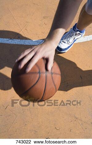 Stock Image - A human hand dribbling a basketball. Fotosearch