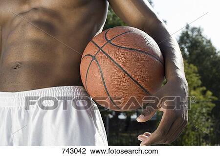 A man holding a basketball, midsection View Large Photo Image Stock Image - A man holding a basketball, midsection. Fotosearch