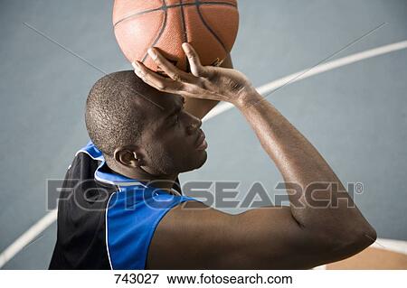 Stock Photo - A man preparing to shoot a basketball. Fotosearch