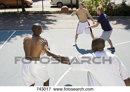 Four men playing basketball View Large Photo Image Stock Photo - Four men playing basketball. Fotosearch
