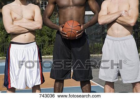Three basketball players, in a row, midsection View Large Photo Image Stock Photograph - Three basketball players, in a row, midsection. Fotosearch