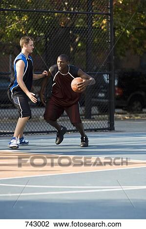 Two men playing basketball View Large Photo Image Stock Image - Two men playing basketball. Fotosearch