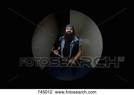 A biker looking threatening and holding a crowbar, viewed through a peephole View Large Photo Image Stock Image - A biker looking threatening and holding a crowbar, viewed through a peephole. Fotosearch