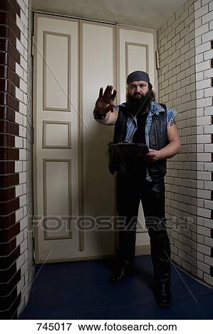 Stock Photo - A bouncer in front of a door. Fotosearch