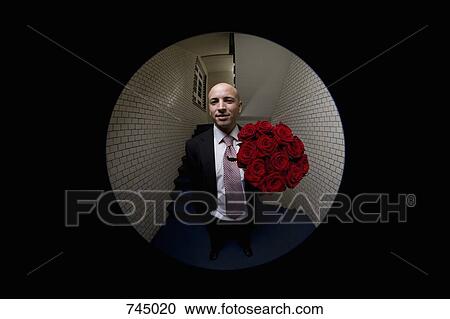 Stock Image - A man with a bouquet of roses viewed through peephole. Fotosearch