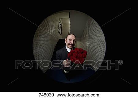 A man with roses and champagne viewed through a peephole View Large Photo Image Stock Photo - A man with roses and champagne viewed through a peephole. Fotosearch