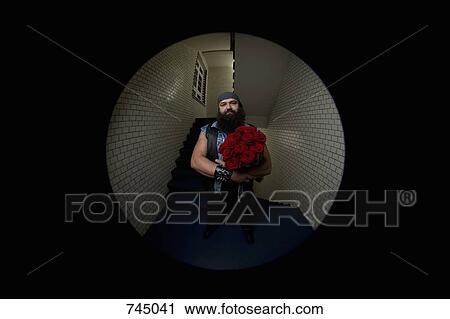 Stock Image - A man with roses viewed through a peephole. Fotosearch