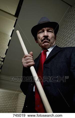 An organized crime boss holding a wood rod View Large Photo Image Stock Photo - An organized crime boss holding a wood rod. Fotosearch