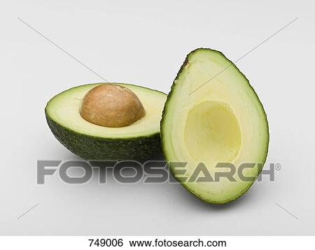 An Avocado Cut In Half Stock Photograph Fotosearch