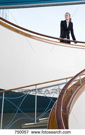 Stock Photo - A businesswoman standing at the top of a staircase. Fotosearch