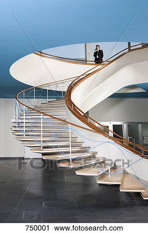 A man talking on his mobile phone at the top of a staircase View Large Photo Image Stock Image - A man talking on his mobile phone at the top of a staircase. Fotosearch