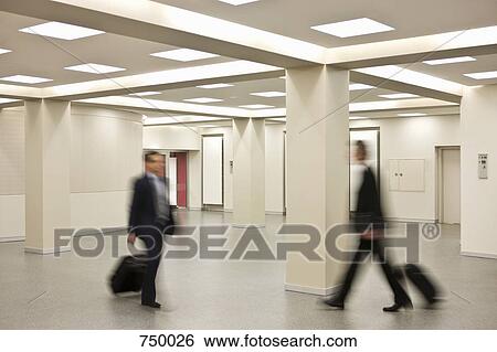 Businessmen pulling suitcases walking in different directions View Large Photo Image Stock Photograph - Businessmen pulling suitcases walking in different directions. Fotosearch
