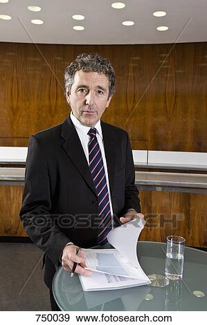 Portrait of a businessman looking at a document View Large Photo Image Stock Photo - Portrait of a businessman looking at a document. Fotosearch