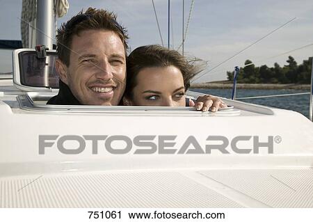 Stock Image - A couple looking above the deck on a yacht. Fotosearch