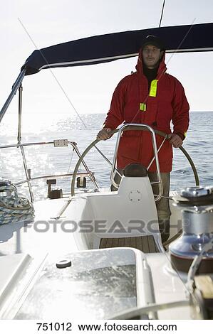 A man at the helm of a yacht View Large Photo Image Stock Image - A man at the helm of a yacht. Fotosearch