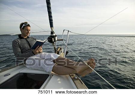 A man reading on the bow of a yacht View Large Photo Image Stock Image - A man reading on the bow of a yacht. Fotosearch