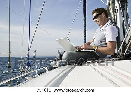 A man using a laptop on a yacht View Large Photo Image Stock Photography - A man using a laptop on a yacht. Fotosearch